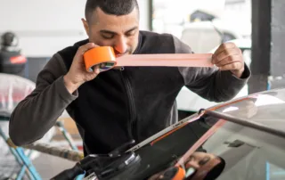 Cracked Windshield Repair vs Replacement technician working on car glass