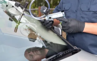 Mobile vs. in-shop auto glass repair technician fixing a windshield