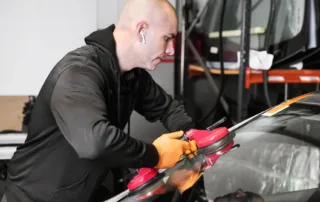Certified technician performing auto glass repair & replacement on a cracked windshield
